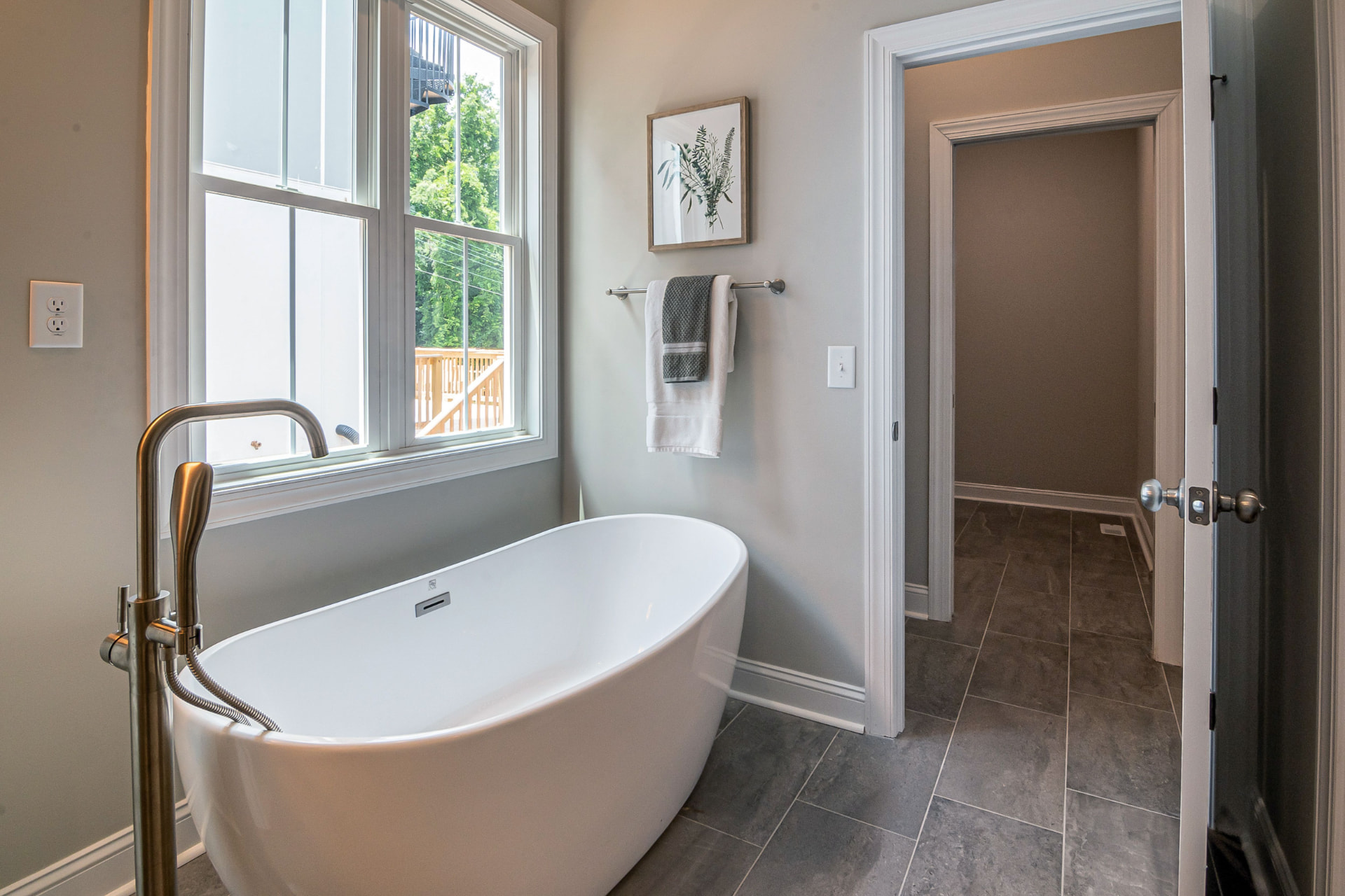 Bright spa bathroom with freestanding tub and natural language towel